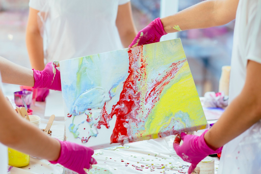 Artist pouring mediums for fluid painting